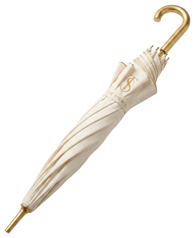 The Source umbrella in cream with the gold monogram