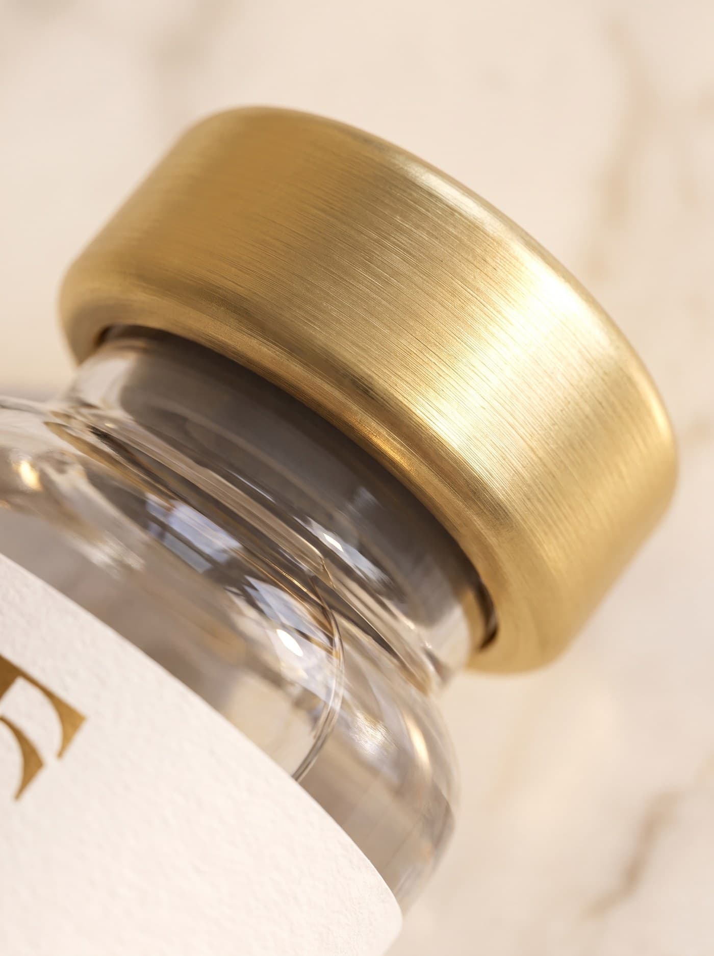 The Source house vial — brushed-gold cap detail